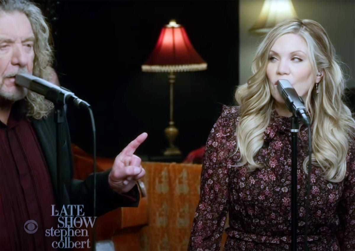 Performance on The Late Show with Stephen Colbert featuring a man in a dark blazer and a woman in a floral dress, both singing into microphones with warm vintage lighting in the background, creating an intimate and classic live music moment.